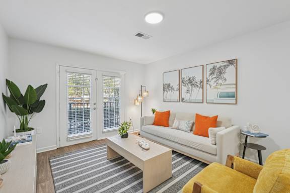 A living room with a white couch, a coffee table, and a striped rug.