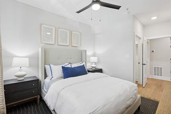 A bedroom with a large bed, a ceiling fan, and a nightstand with a lamp at Union Eleven Apartments, Atlanta, Georgia