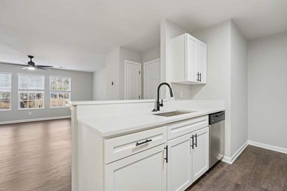 A kitchen with white cabinets and a sink.