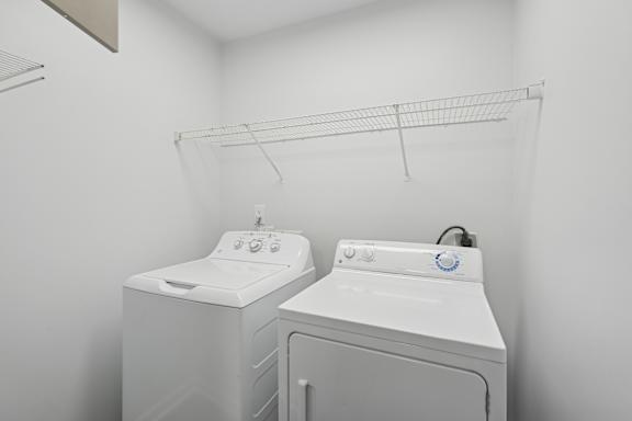 Two white front loading washing machines in a laundry room.
