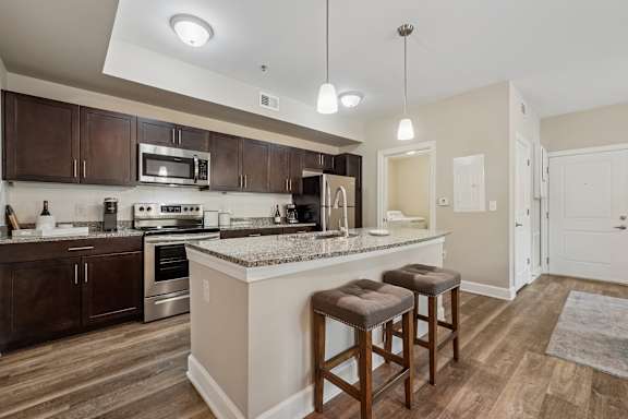 A kitchen with a bar area and two stools.