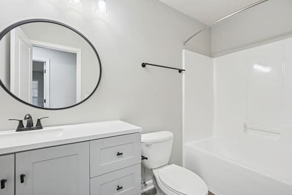 A white bathroom with a toilet, sink, and bathtub.