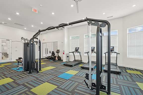 A gym with a variety of equipment including treadmills and weight machines.