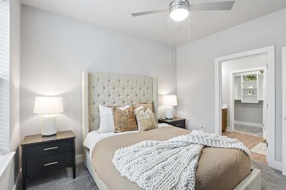 A bedroom with a large bed and a ceiling fan.