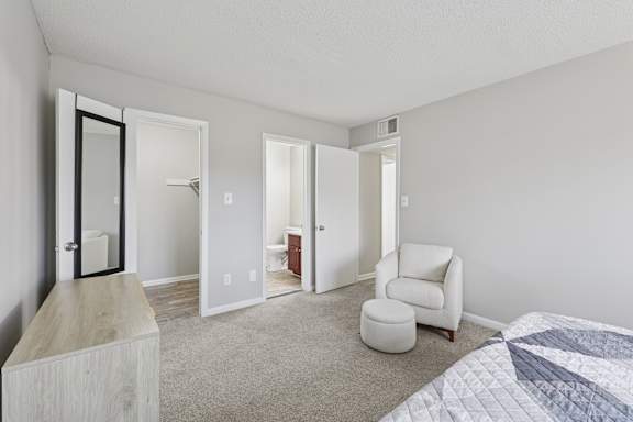 A bedroom with a bed, chair, and a cabinet.