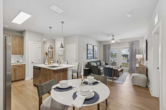 A modern kitchen with a dining table set for two.