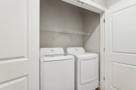 A white laundry room with a washer and dryer.