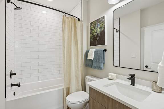 A white bathroom with a toilet, sink, and shower at Union Eleven Apartments, Atlanta, 30324