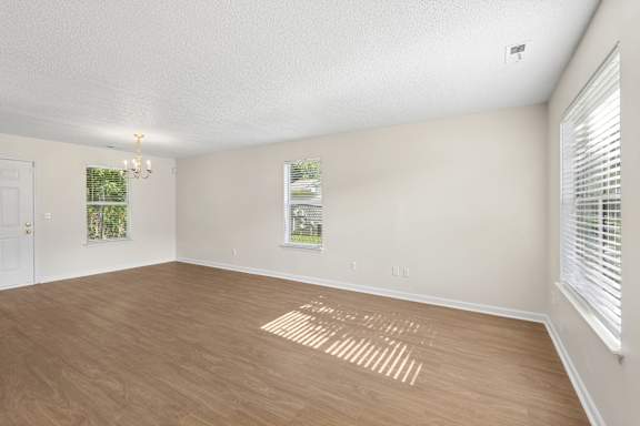 A room with wooden flooring and a window with blinds.