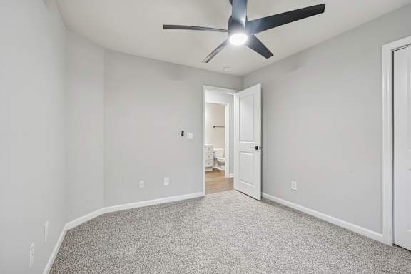 A room with a ceiling fan and carpeted floor.