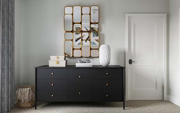 A black dresser with a mirror and some decorations on top at The SoHo Luxury Apartments, North Carolina 27603