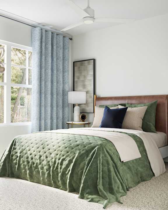 A bed with a green comforter and a white blanket on it at The SoHo Luxury Apartments, Raleigh
