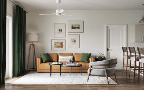 A living room with a sofa, chairs, and pictures on the wall at The SoHo Luxury Apartments, Raleigh