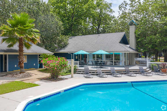 the pool and patio of a house with chairs and a swimming pool at West Wind Landing, Savannah, GA, 31410