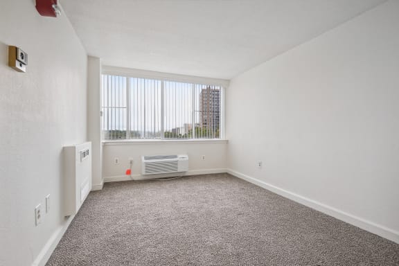 an empty room with carpet and a window