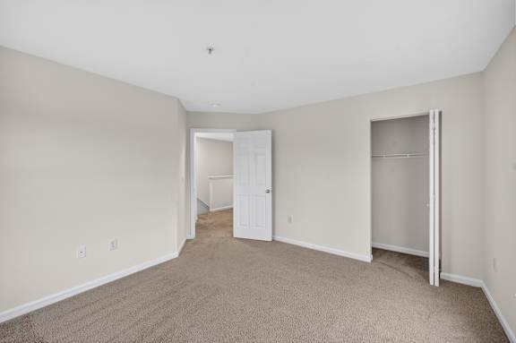 A room with a carpeted floor and a white door.