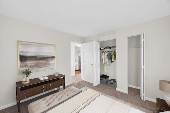 A bedroom with a bed, a dresser, and a painting on the wall.