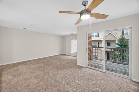 A room with a ceiling fan and carpeted floor.