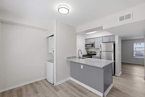 A kitchen with a white fridge, microwave, and oven.