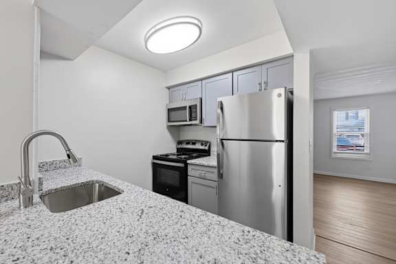 A kitchen with a granite countertop and stainless steel appliances.