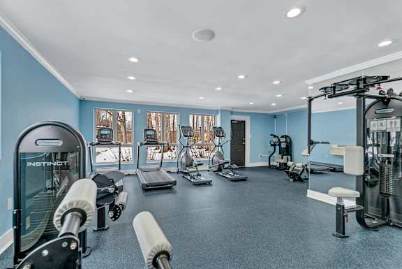 A gym with a variety of equipment including treadmills, weights, and exercise machines.