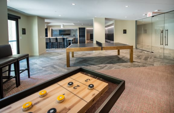 a large living room with a pool table   and a kitchen