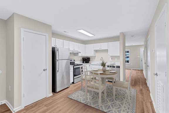 A kitchen with a table and chairs in the middle of the room.