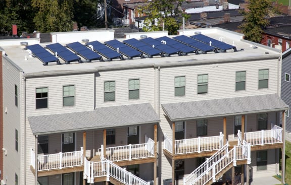 Arlington Grove apartment building with patios with stairs and on the roof are solar panels