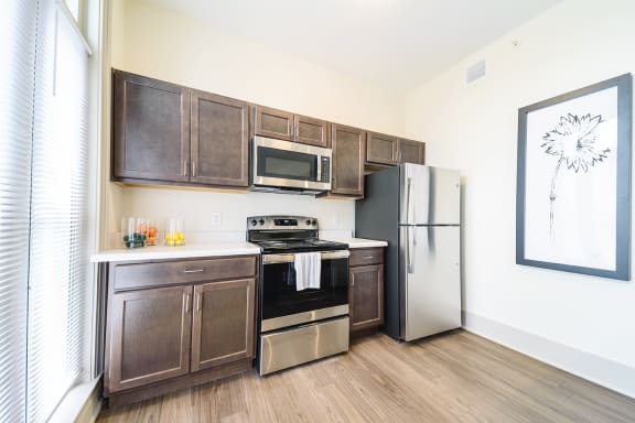 a kitchen with stainless steel appliances and wooden cabinetsat Art Lofts at Dayton Arcade apartments in Dayton, OH