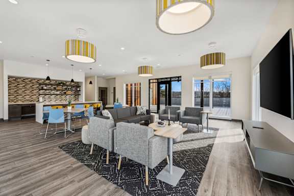 A modern living room with a grey couch and a wooden floor.