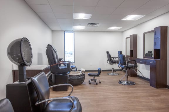 a salon room with a variety of chairs and a window