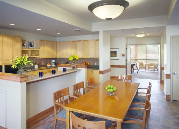 a kitchen and dining room with a wooden table and chairs at Cahill House Senior Apartments in St. Louis, MO
