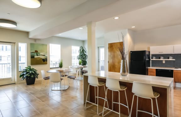 a kitchen and dining room with a counter and chairs