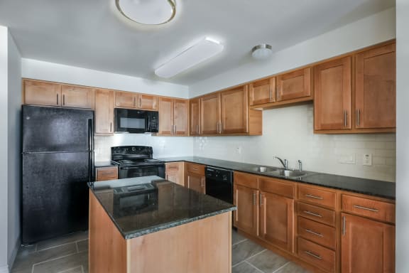 a kitchen with black appliances and wooden cabinets
