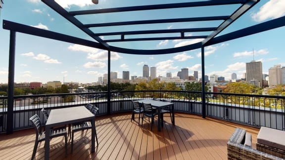 a balcony with a view of a city and a table and chairs