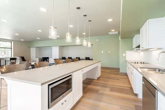 A modern kitchen with white cabinets and stainless steel appliances.