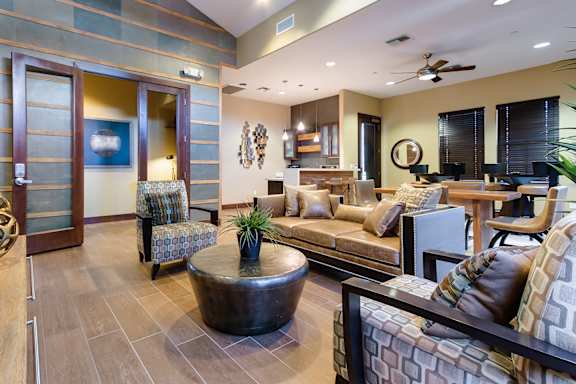 A living room with a brown coffee table and a couch with a pillow on it.