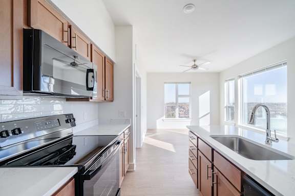 A modern kitchen with a stove, microwave, and sink.