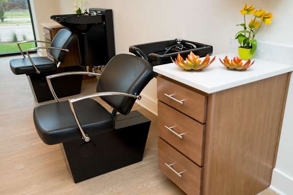 A black chair with a white handle is in front of a wooden cabinet.