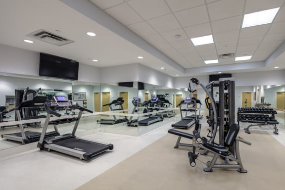 a gym with treadmills and other exercise equipment in a large room