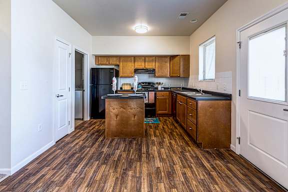 A kitchen with wooden floors and white walls.