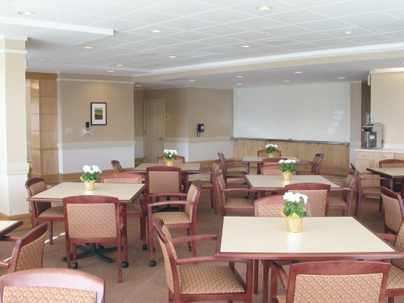 a dining room with tables and chairs and flowers in vases
