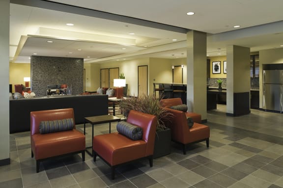 a lobby of a hotel with chairs and a reception desk