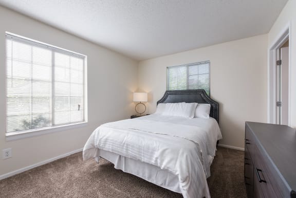 a bedroom with a bed and a dresser and a window at Heritage Park Apartments and Townhomes in Minneapolis, MN