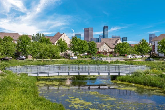 a bridge over a body of water with a city in the background at Heritage Park apartments and townhomes in Minneapolis, MN