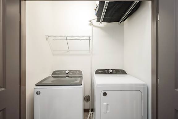 A small laundry room with a washer and dryer.