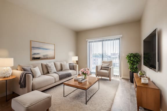 A living room with a couch, chair, and television.