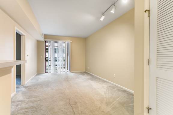 A room with a white door and a window with blinds.