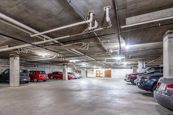 A parking garage with several cars parked.