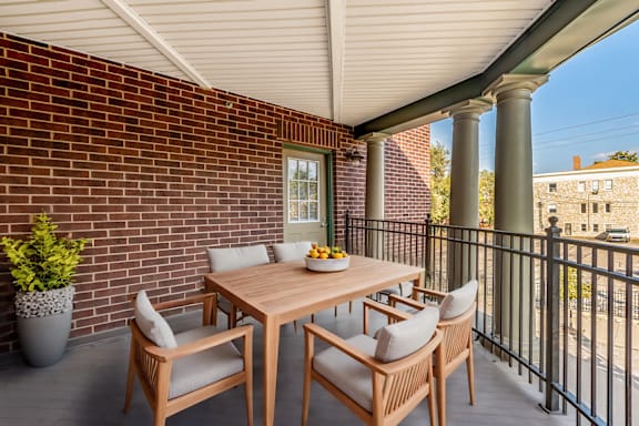 A table with chairs is on a balcony.